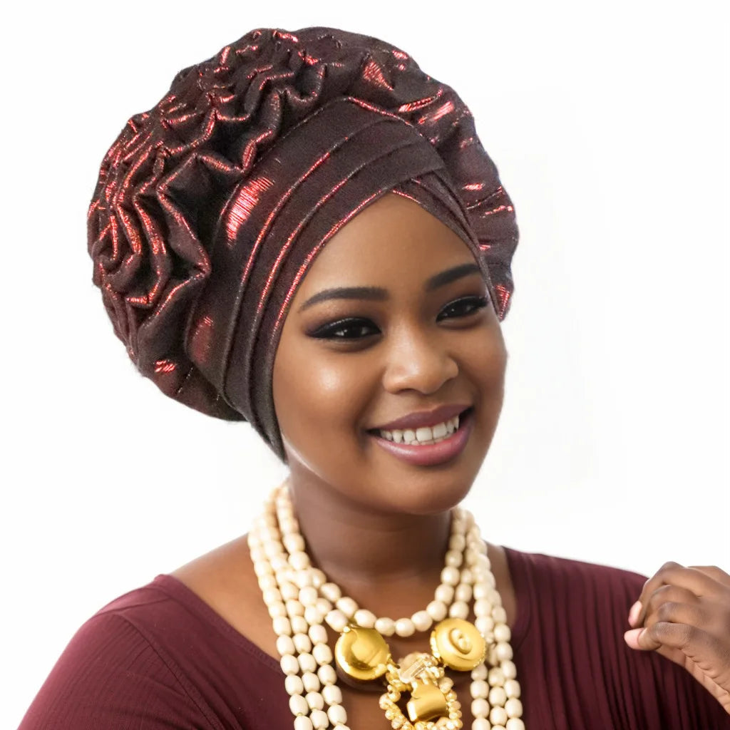 Woman wearing a wine red pre-tied auto gele with coral bead jewellery