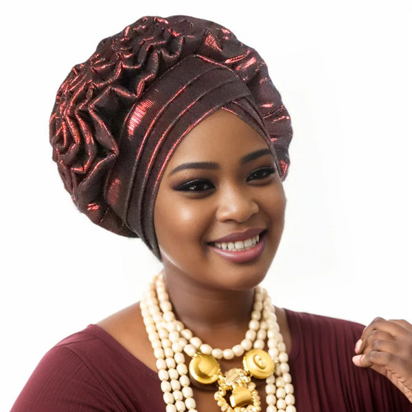 Woman wearing a wine red pre-tied auto gele with coral bead jewellery