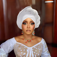 Woman wearing a raw silk pre-tied auto gele head wrap