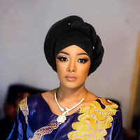 Woman wearing a raw silk pre-tied auto gele head wrap