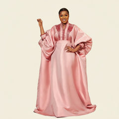 Pink metallic brocade boubou gown with bell sleeves and beaded neckline, worn by a model